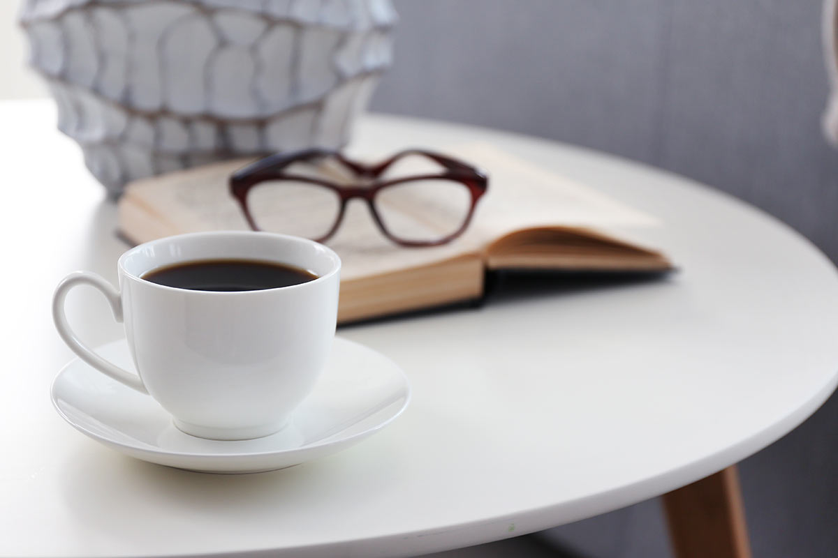A cup of coffee with book on table in room